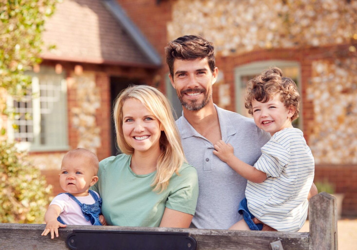 Financial Solutions Tailored for You - Photo Of Smiling Family Standing By Gate Outside Home In Countryside Together